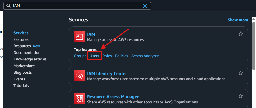 Tela do Console da AWS com a barra de busca contendo o texto "IAM" e destaque com seta e retângulo vermelho sobre a opção "Users" dentro do serviço IAM.