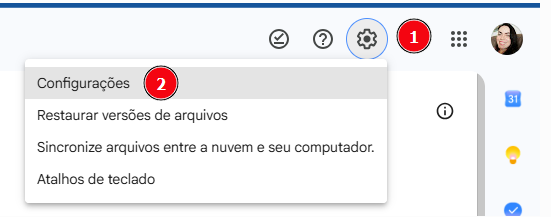 Captura de tela da interface do Google Drive em português. No canto superior direito, o ícone de engrenagem está destacado com um círculo azul e marcado com o número vermelho “1”. Abaixo dele, aparece um menu suspenso com as opções “Configurações”, “Restaurar versões de arquivos”, “Sincronize arquivos entre a nuvem e seu computador.” e “Atalhos de teclado”. A opção “Configurações” no topo do menu está marcada com o número vermelho “2”. Ao lado, também aparecem os ícones de ajuda, notificações com o número 1, menu de aplicativos e foto de perfil.