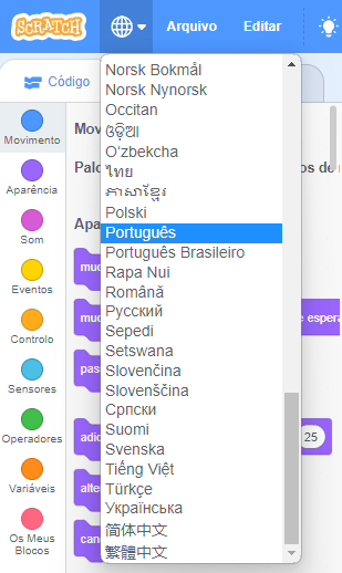 Captura de tela do canto esquerdo da página de edição e criação de jogos e animações do site "Scratch", mostrando a bolinha com grades. Nas opções há variados idiomas mostrados, mas com foco em português. Abaixo de português há o português brasileiro.