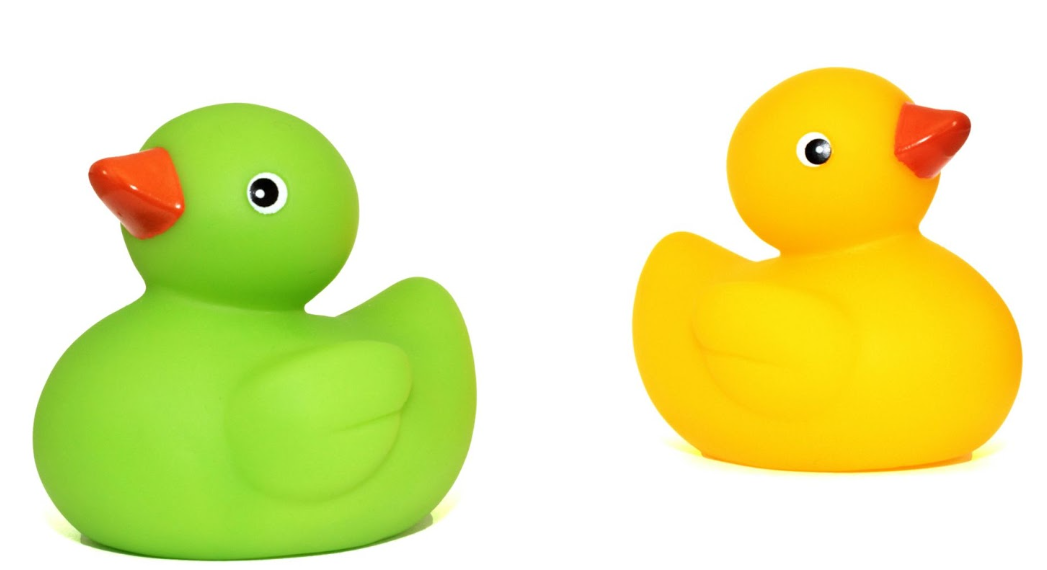 Dois patos de borracha, um verde virado para esquerda e um amarelo, virado para direita.